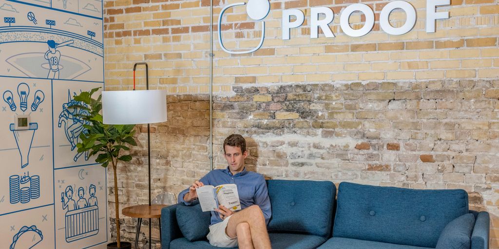 man sitting on blue sofa while reading book