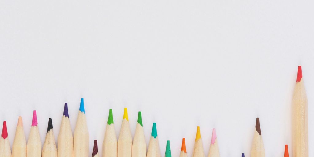 colored pencil lined up on top of white surface