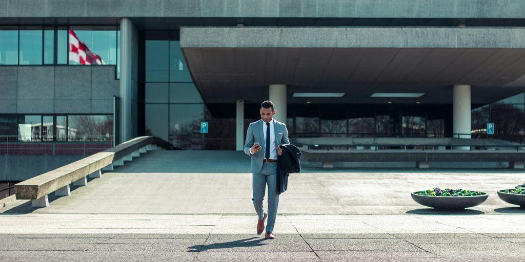 man walking while holding black coat